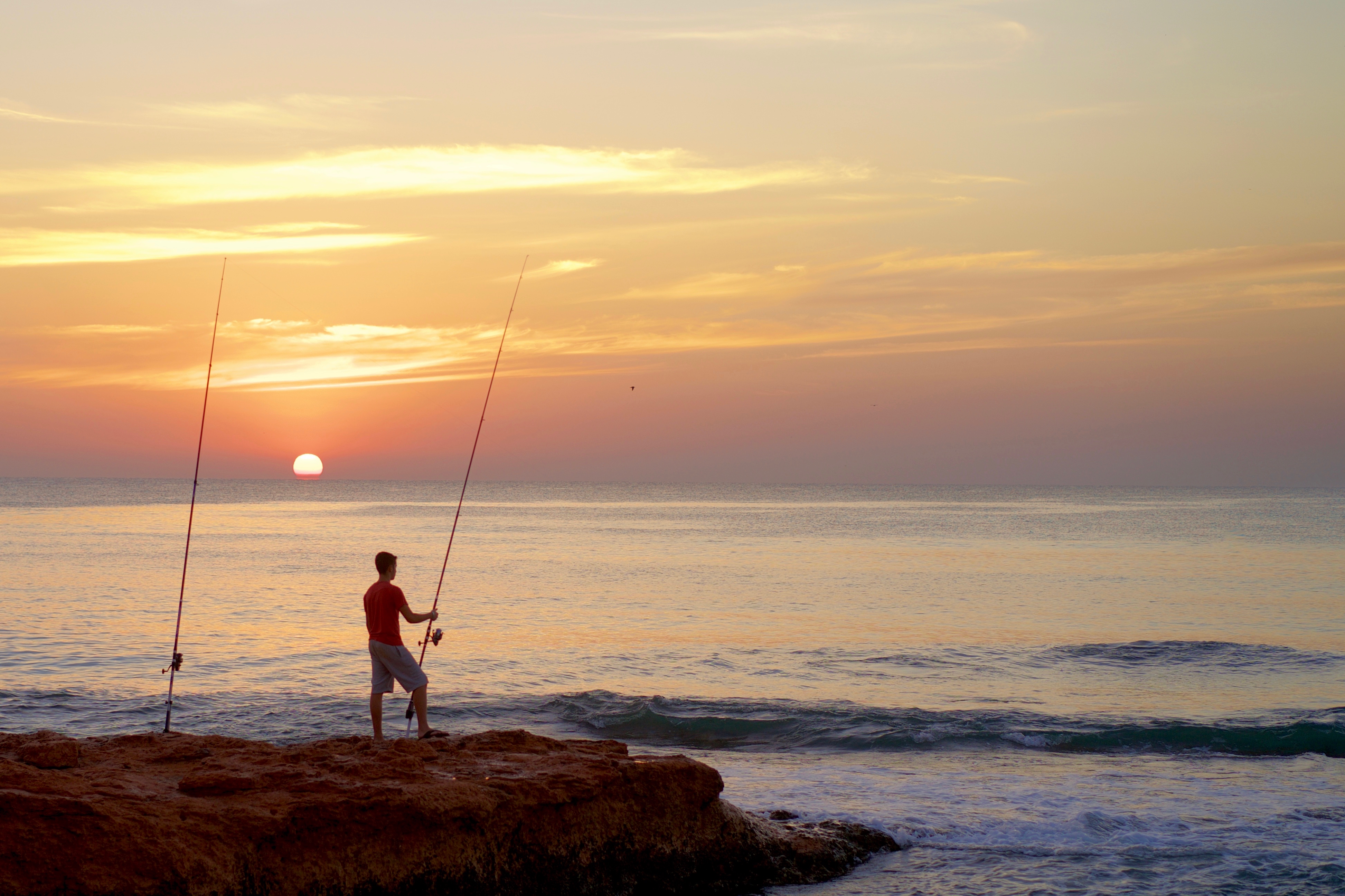 The fisherman and his rods are the focus of this sunrise shot.